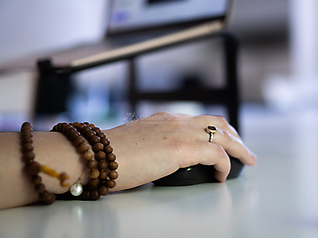 Beyond The Frame: Junge Perspektiven auf Vielfalt im Glauben - Frau mit Gebetskette arbeitet am Computer